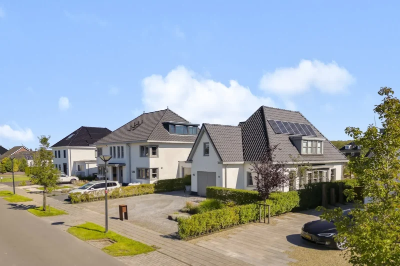 Witte woning met donker dak, gefotografeerd door Housevertising